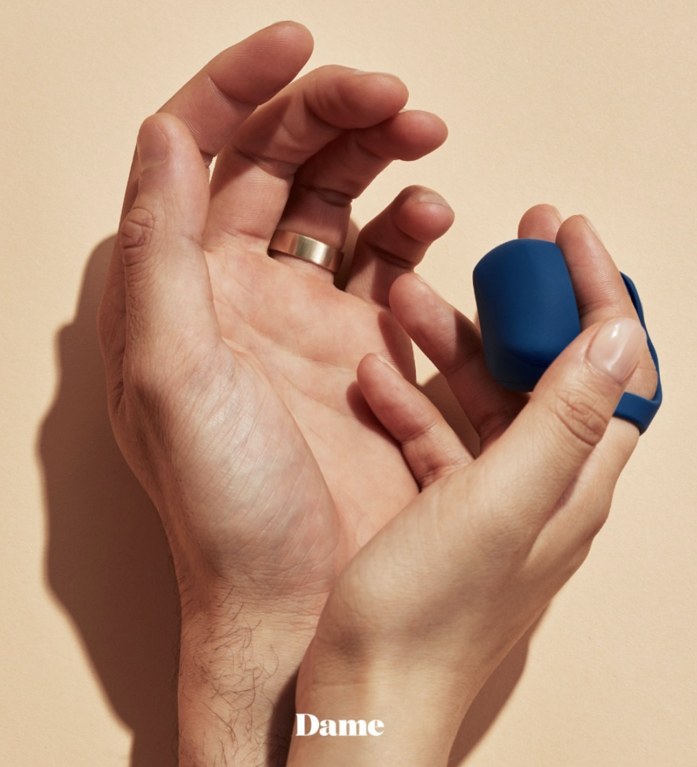 Model holding blue finger vibrator on hands