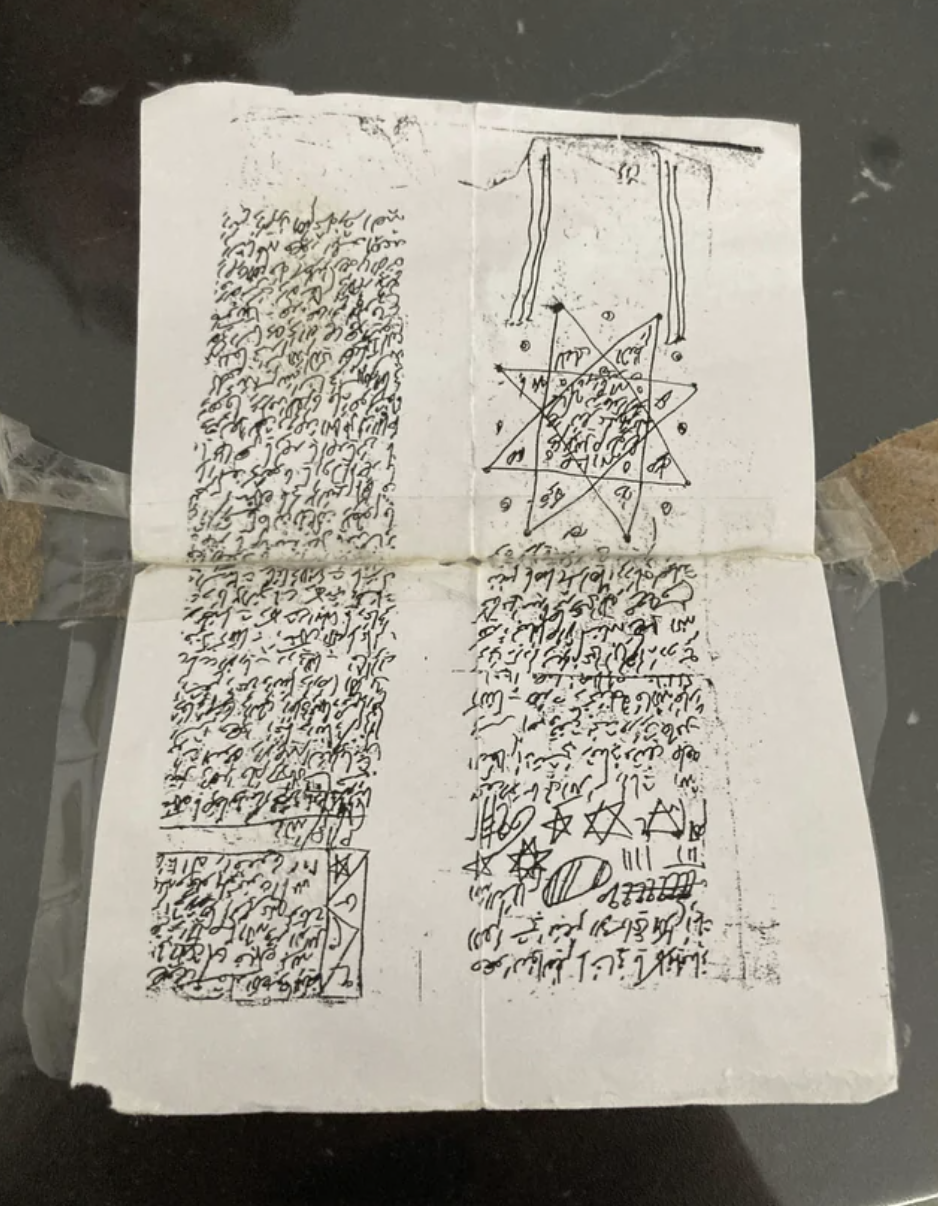 folded piece of paper covered in symbols and strange writing