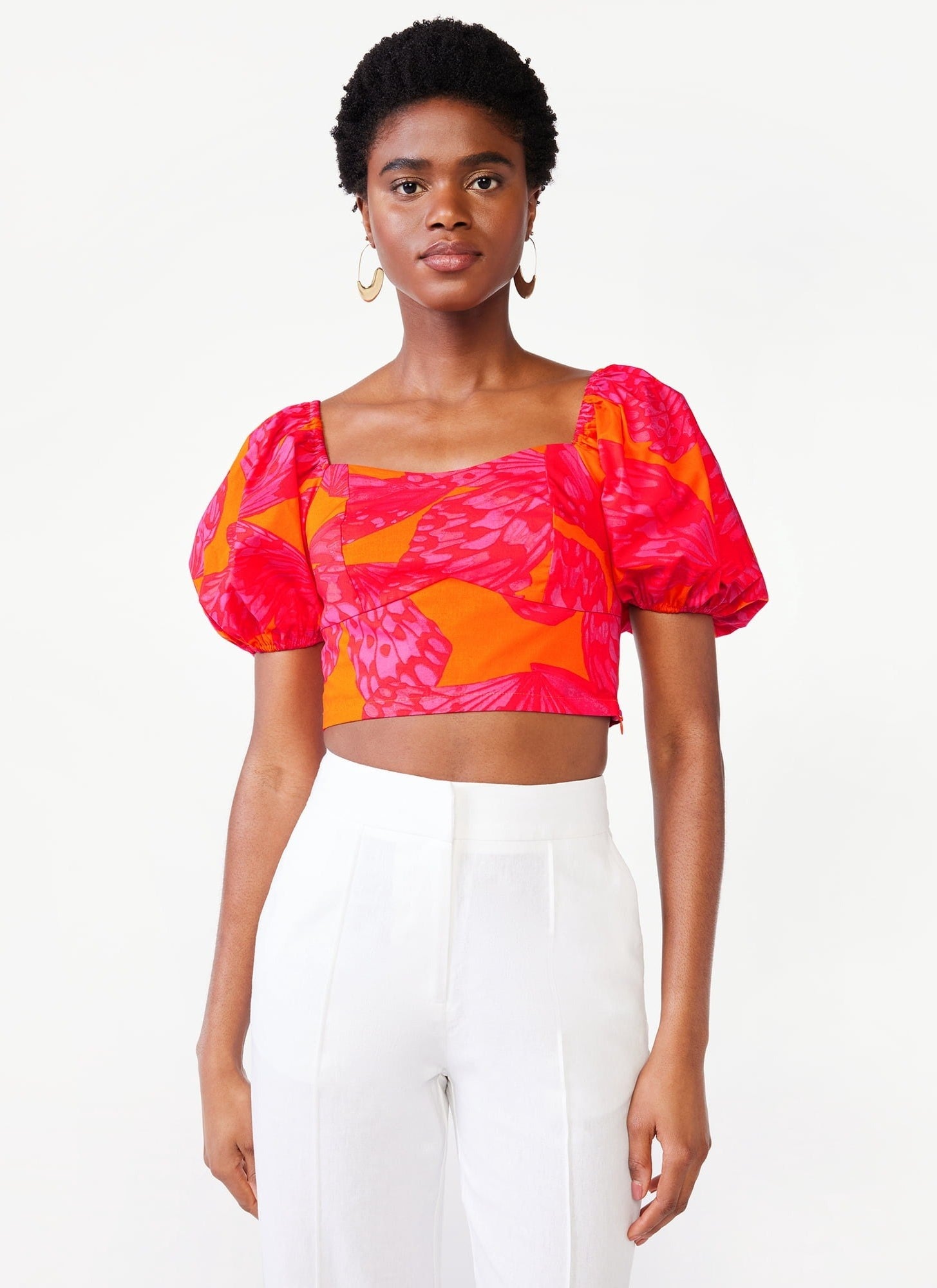 A model in the pink and orange butterfly print crop top