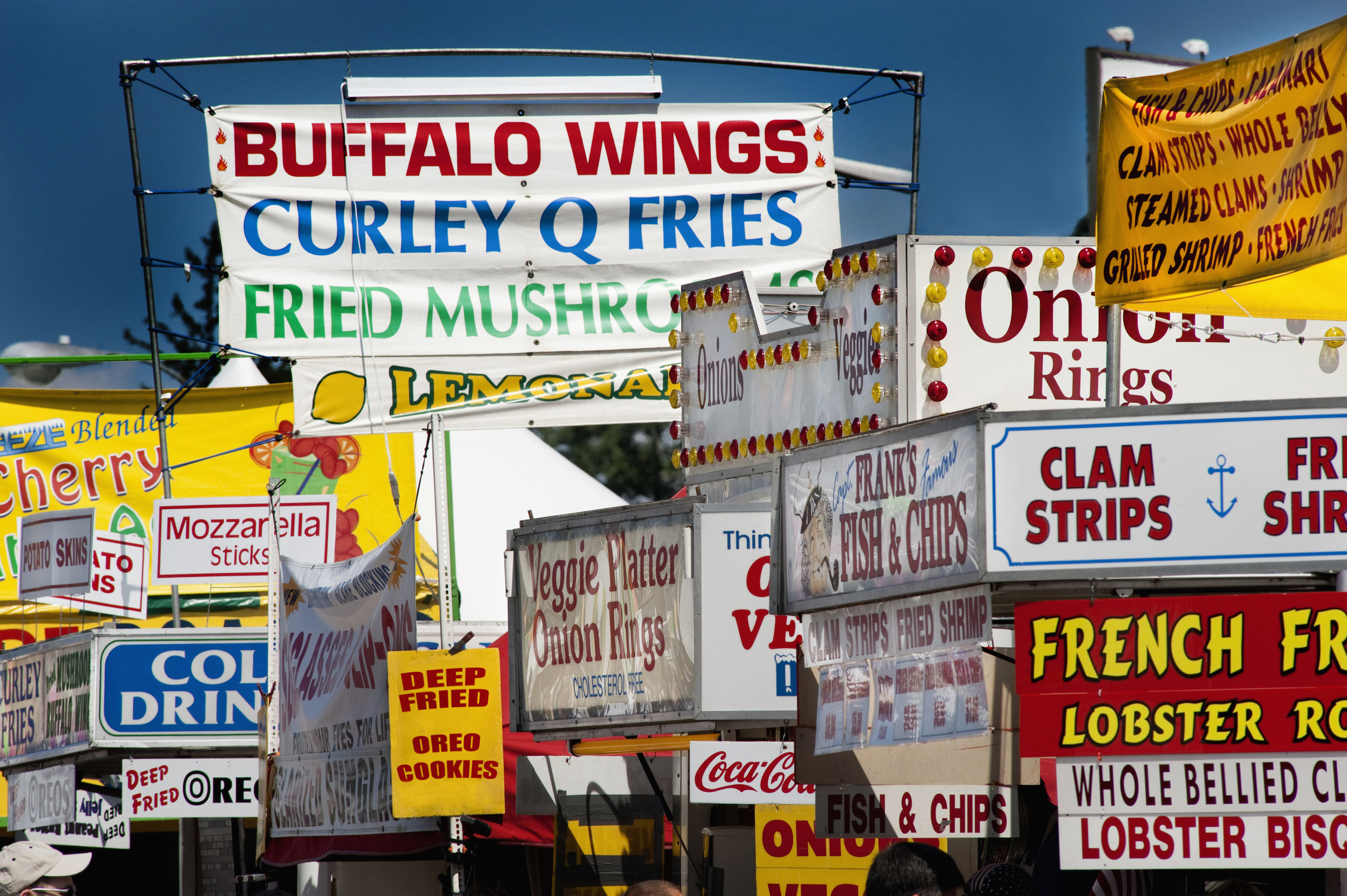 Food stands selling fried foods at a fair.