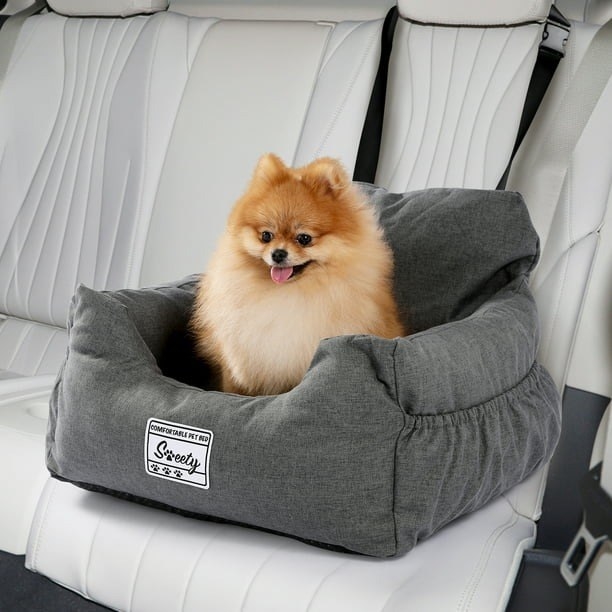 a dog sitting in a booster seat