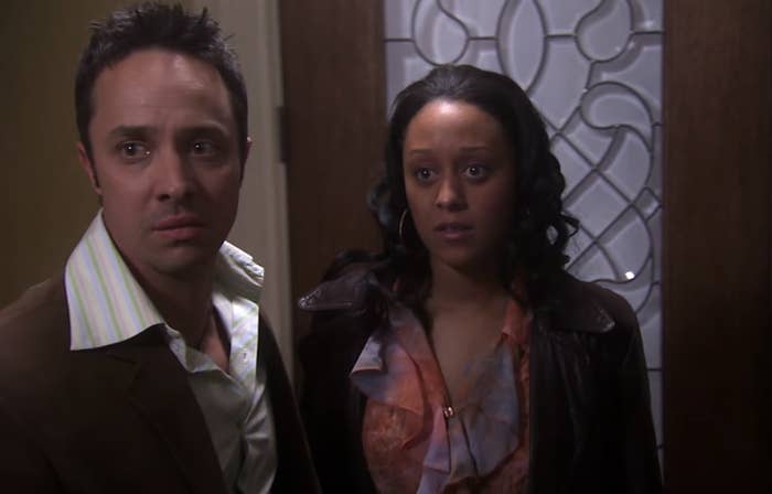 closeup of tia and a costar standing by a door during a scene