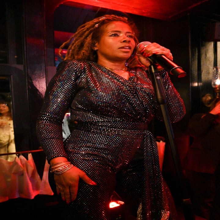 Close-up of Kelis performing in a sparkly pantsuit