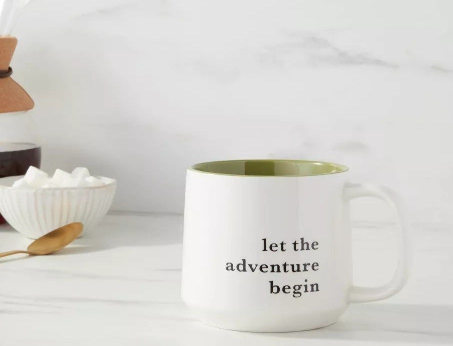 The white mug with the words &quot;let the adventure begin&quot;