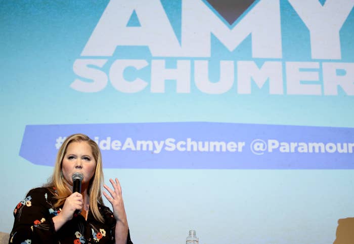 Amy Schumer speaking into a microphone on stage