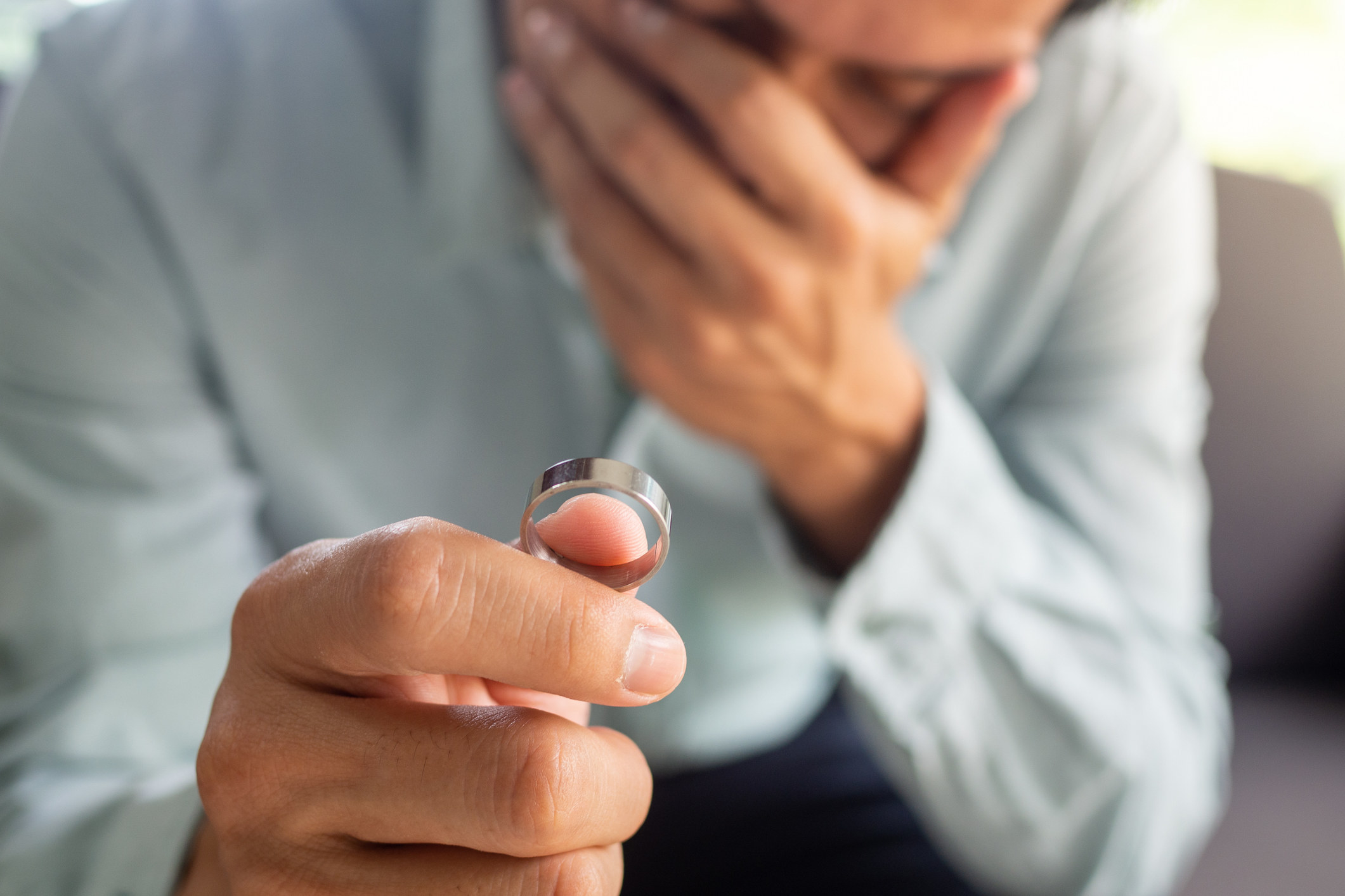 man crying holding a wedding ring