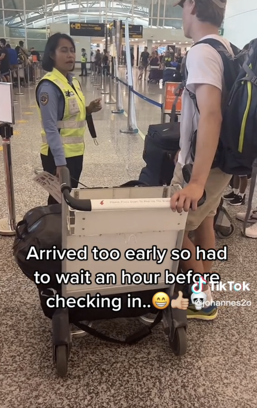Rolv speaking to an airport agent with the caption, &quot;Arrived too early so had to wait an hour before checking in&quot; with grinning face, thumbs-up, and skull emojis