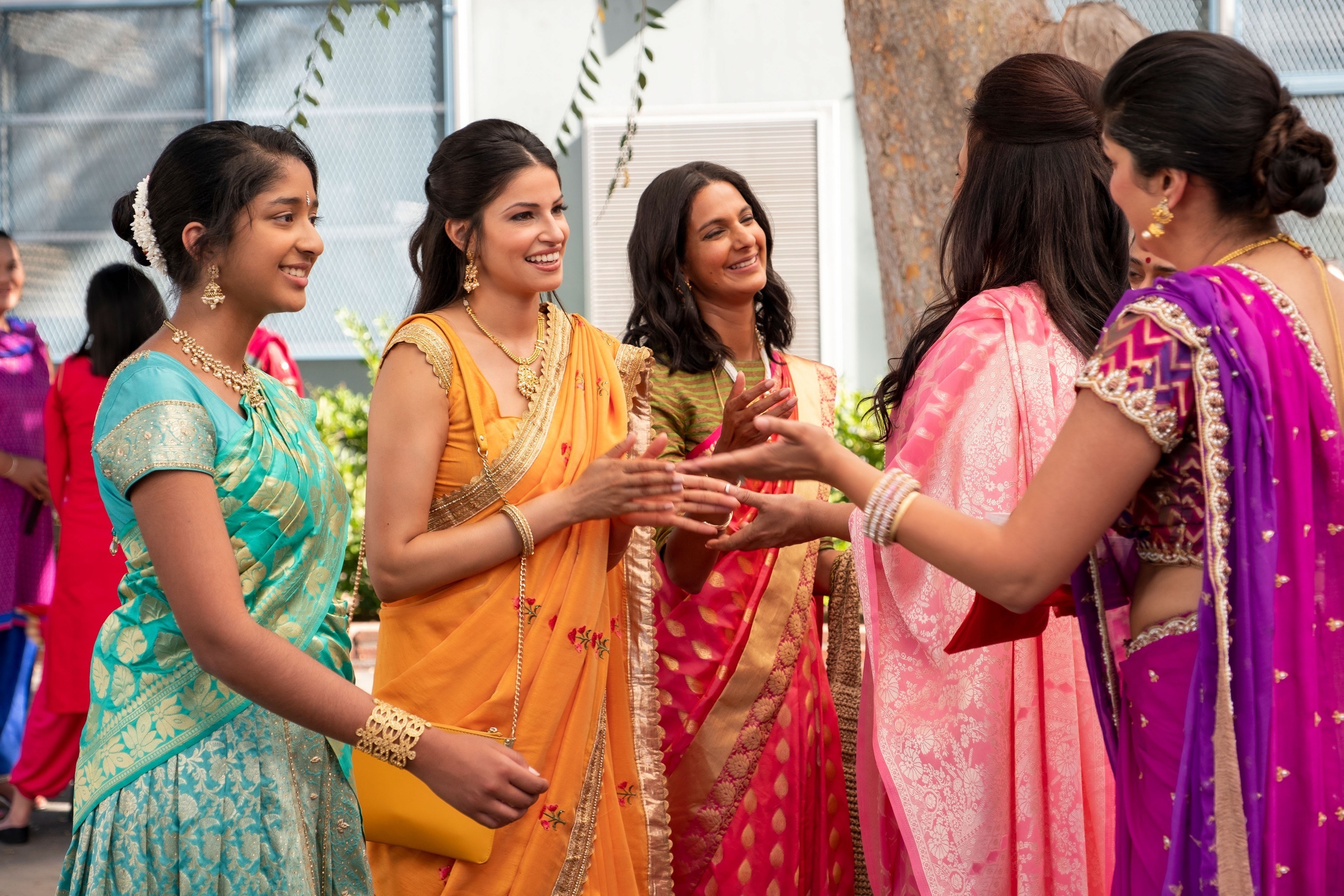 Kamala standing next to Devi and speaking to other woman at a gathering