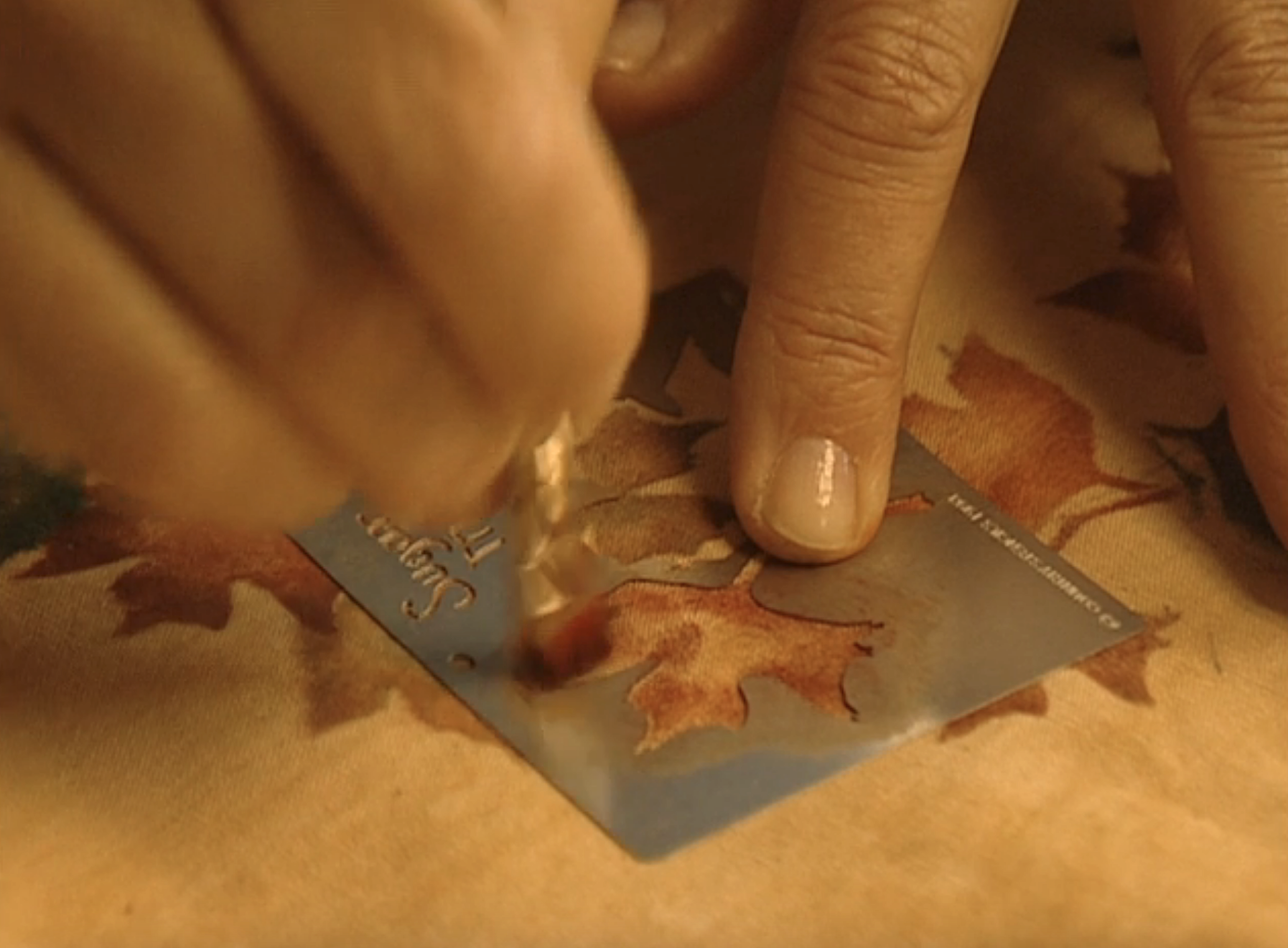 closeup of hands using a stencil