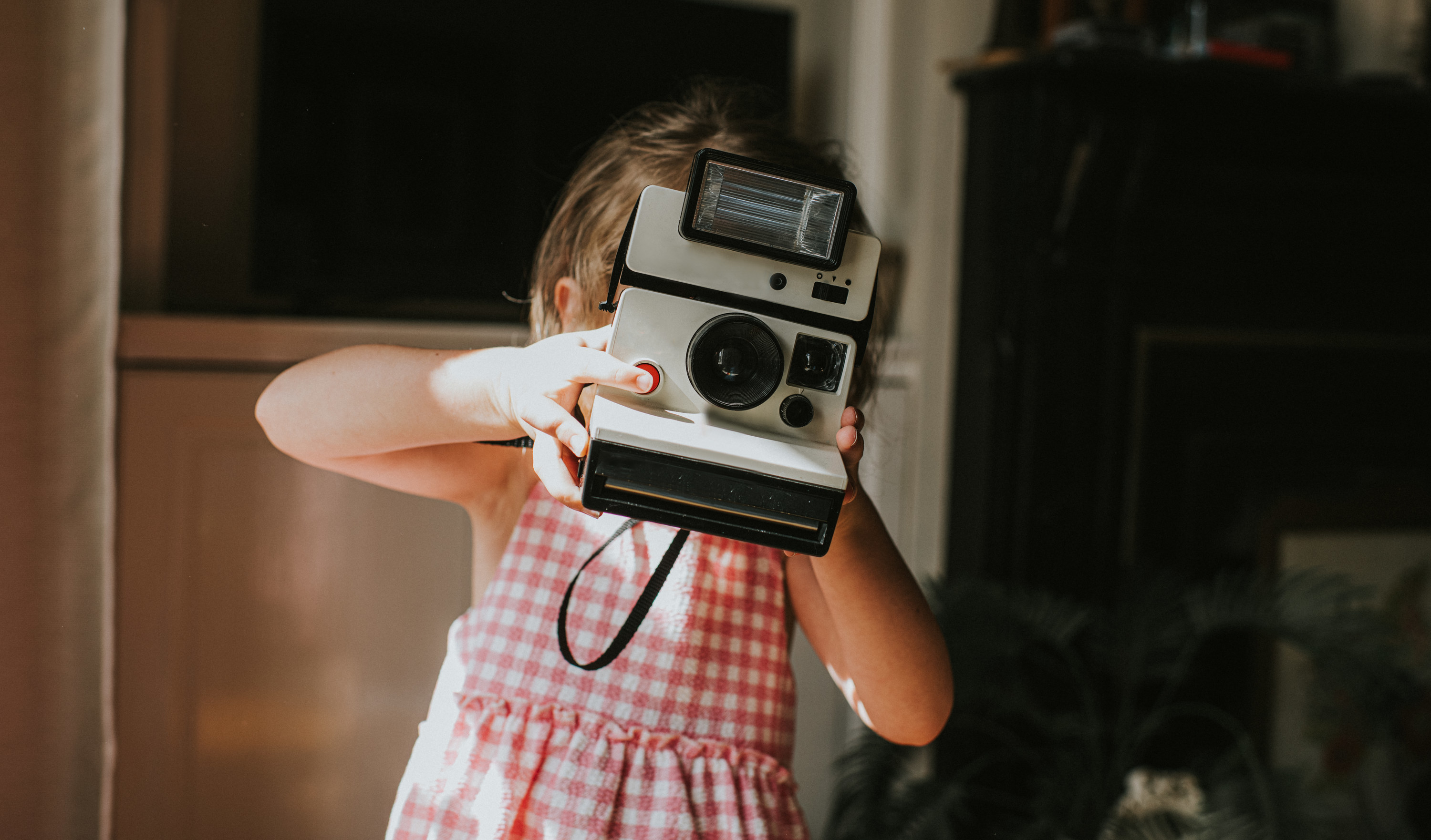 child holds a polaroid camera