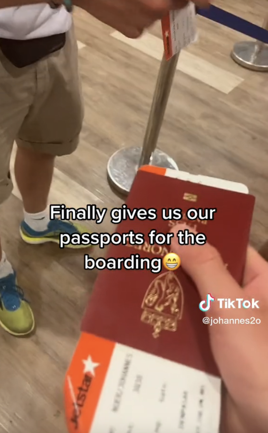 Close-up of hand holding passport with caption &quot;Finally gives us our passports for the boarding&quot; with smile emoji
