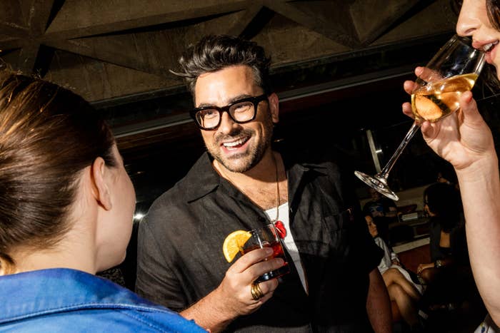 Actor Dan Levy holding a cocktail
