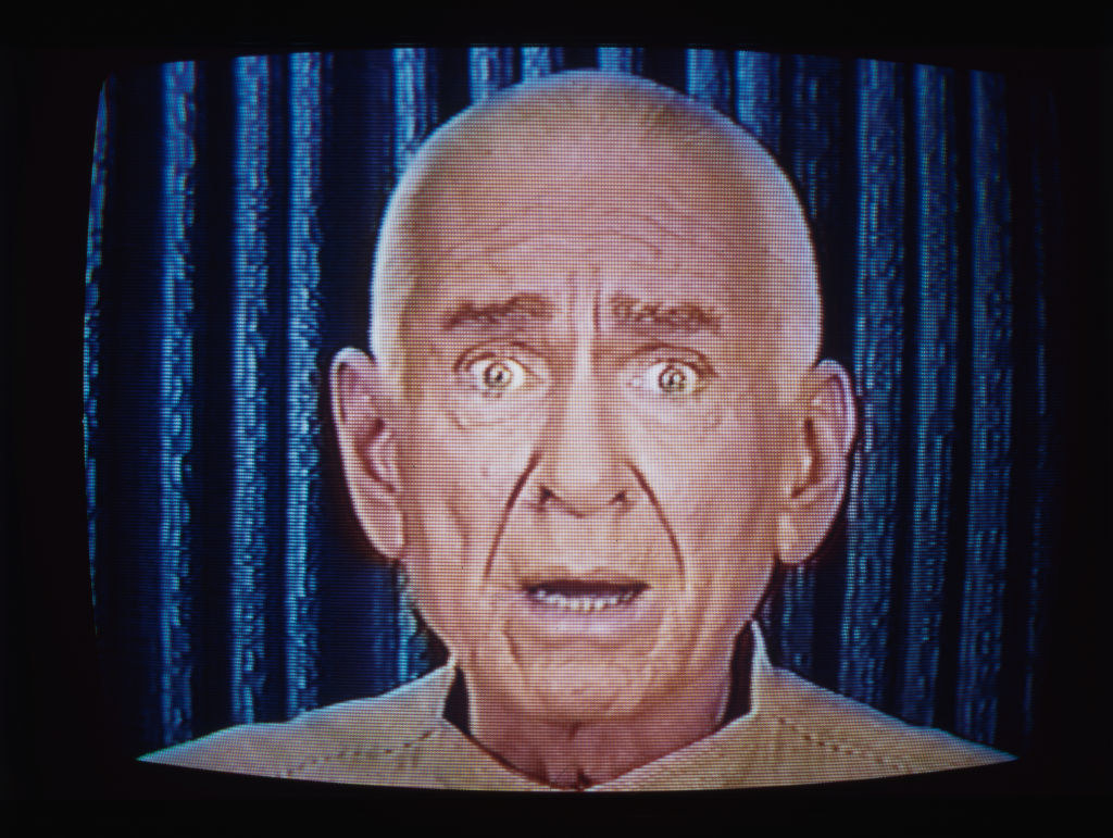 old man on a screen with his eyes wide and mouth open
