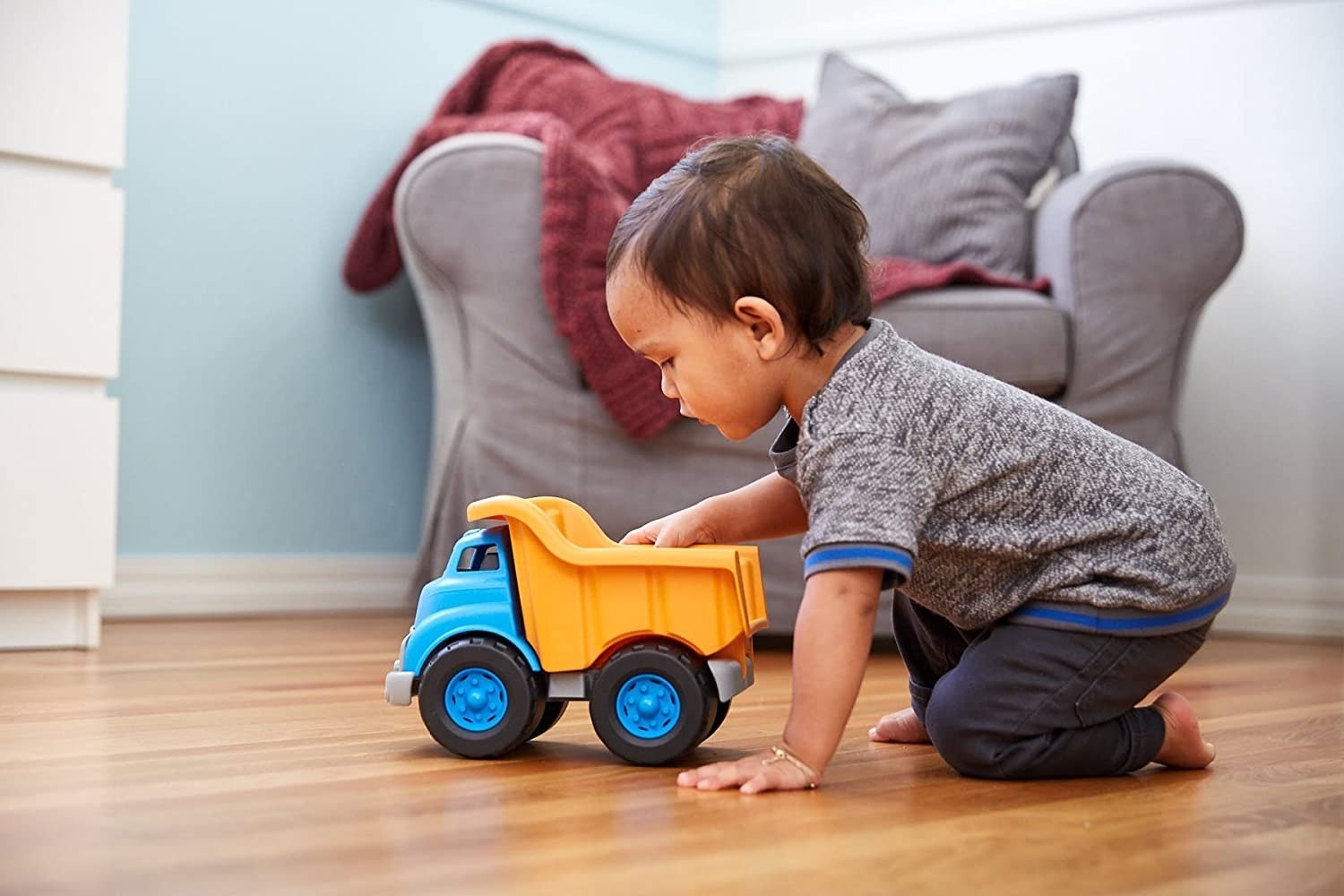 Child plays with a toy dump truck