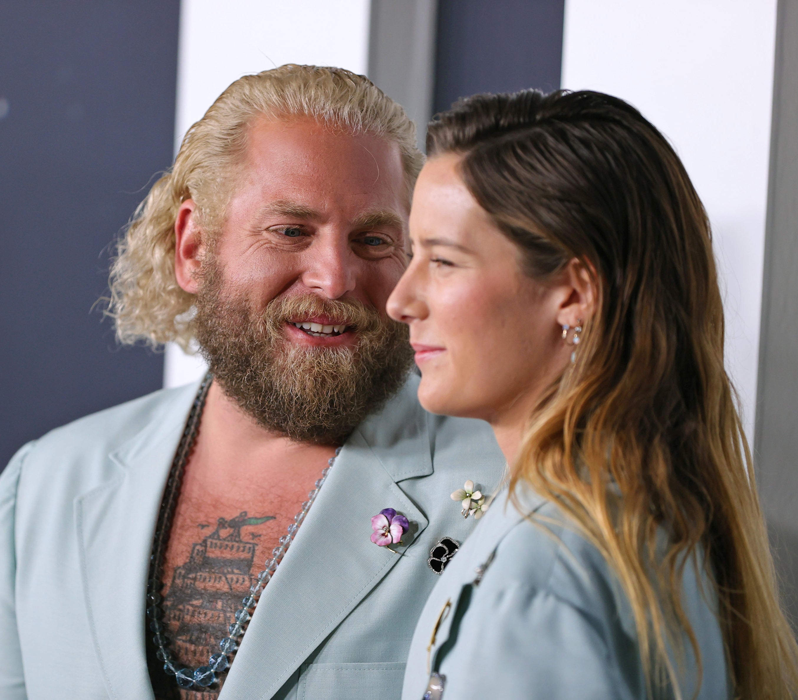 Close-up of Jonah and Sarah at a press event wearing matching suits