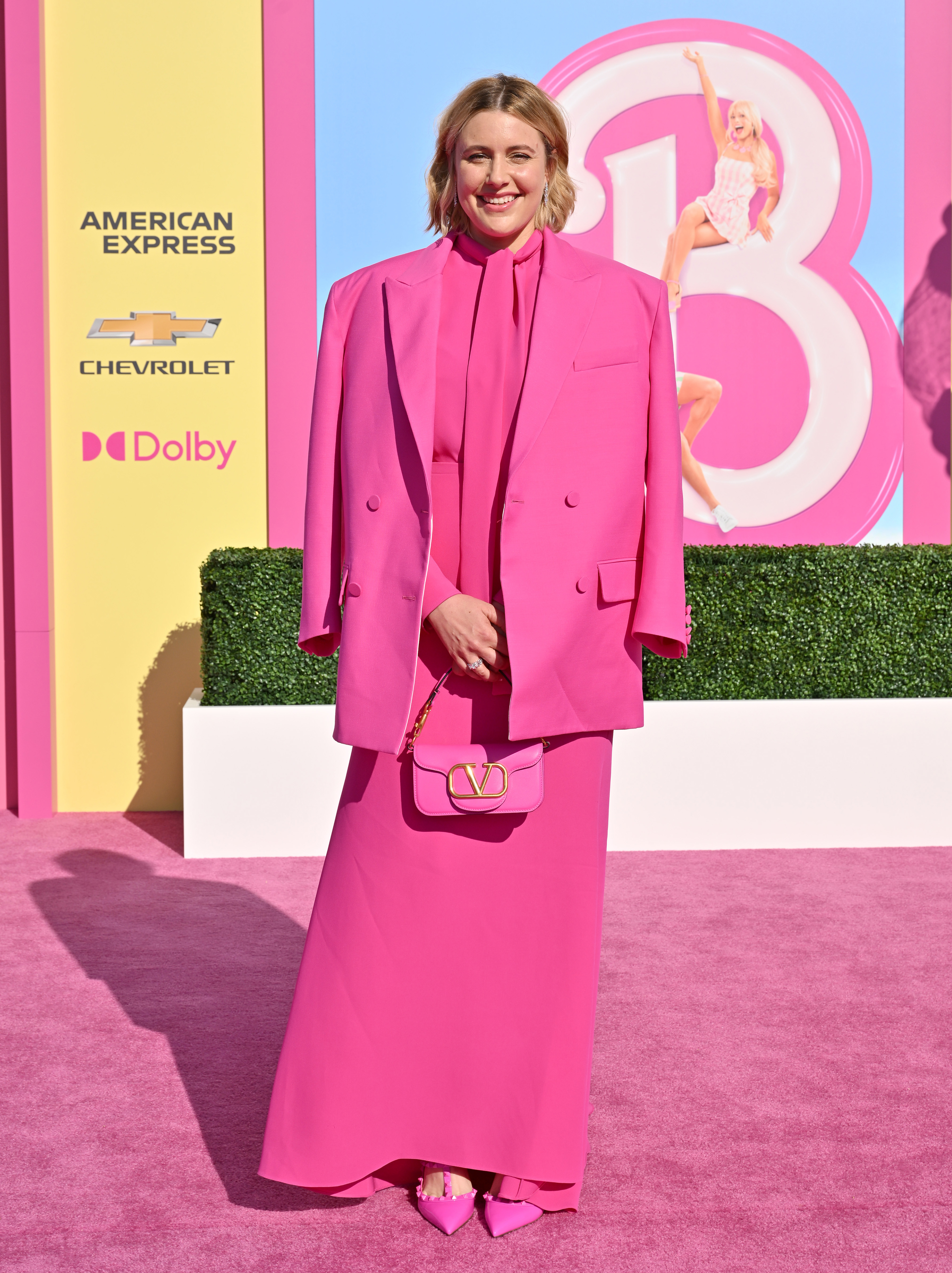 In a pink suit jacket and pink gown