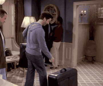 ross picking up his suitcase but it opens up and all the things he stole from the hotel fall out