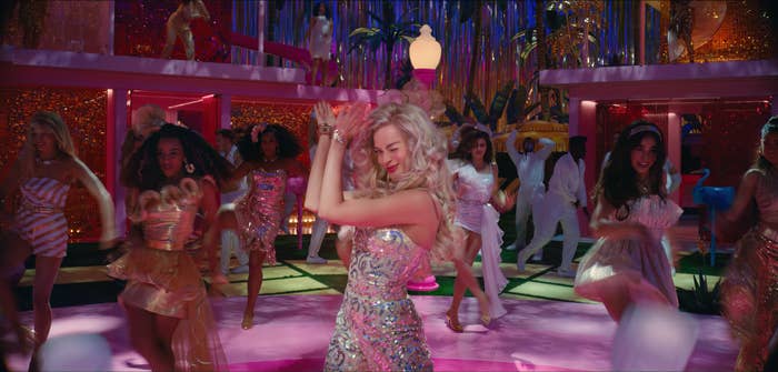 Margot as Barbie dancing with others in the background