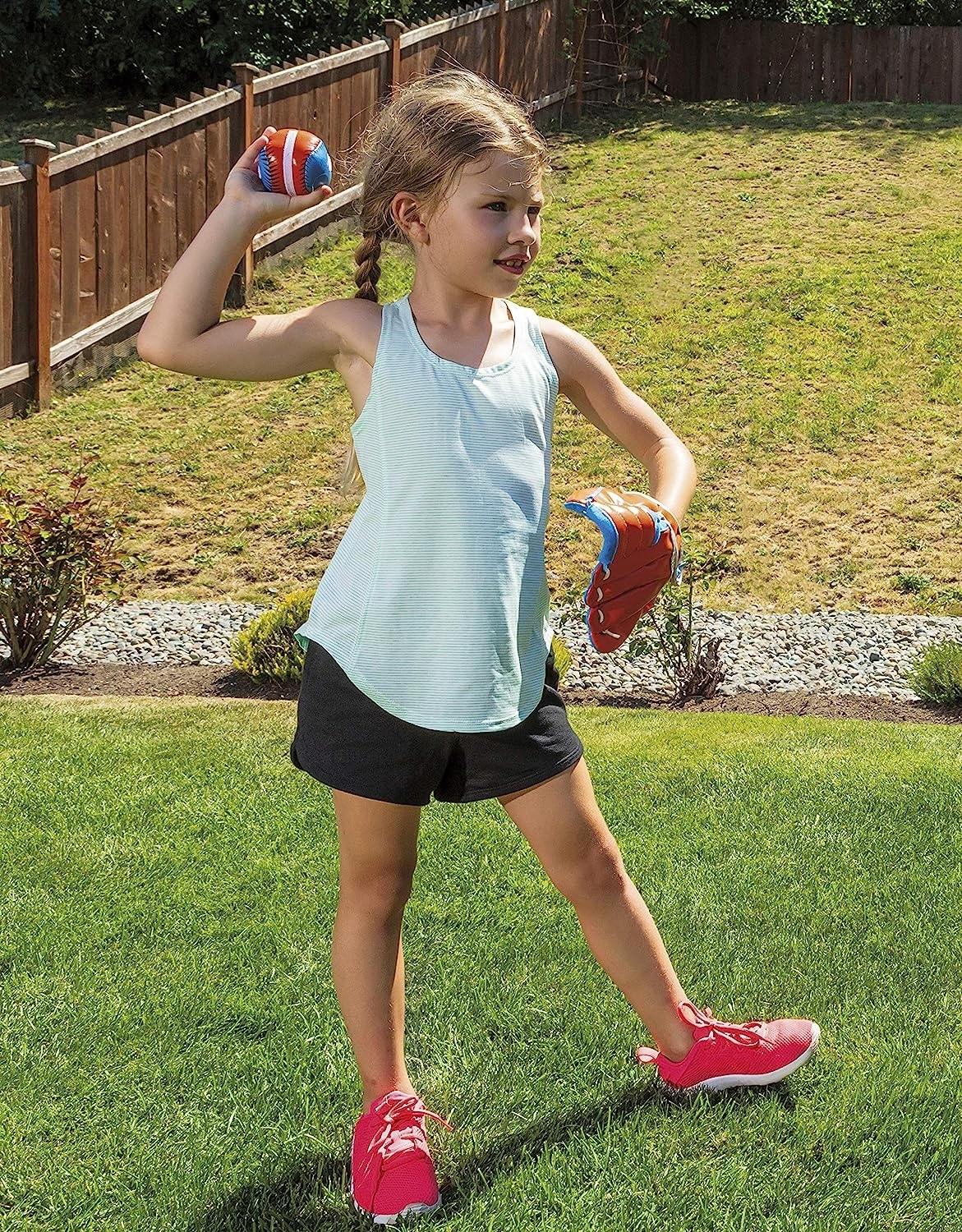 Child with red and blue mitt on hand throwing ball with the other hand