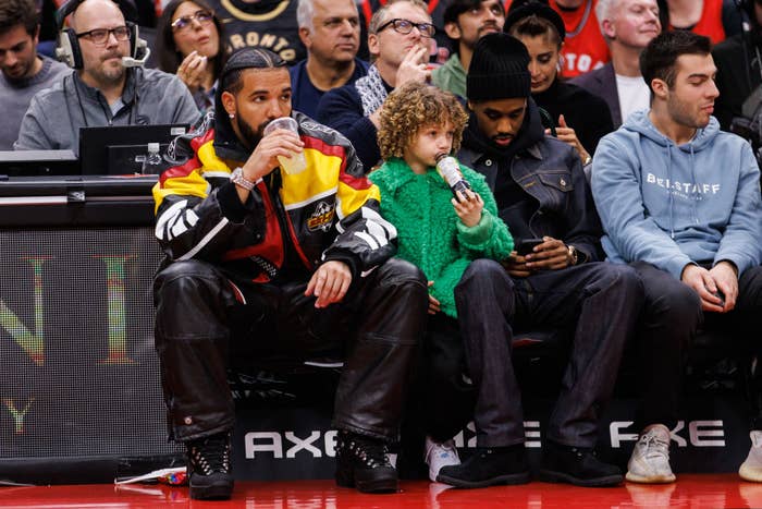 Rapper Drake sits court side with his son Adonis during the second half of the NBA game between the Toronto Raptors and the LA Clippers at Scotiabank Arena