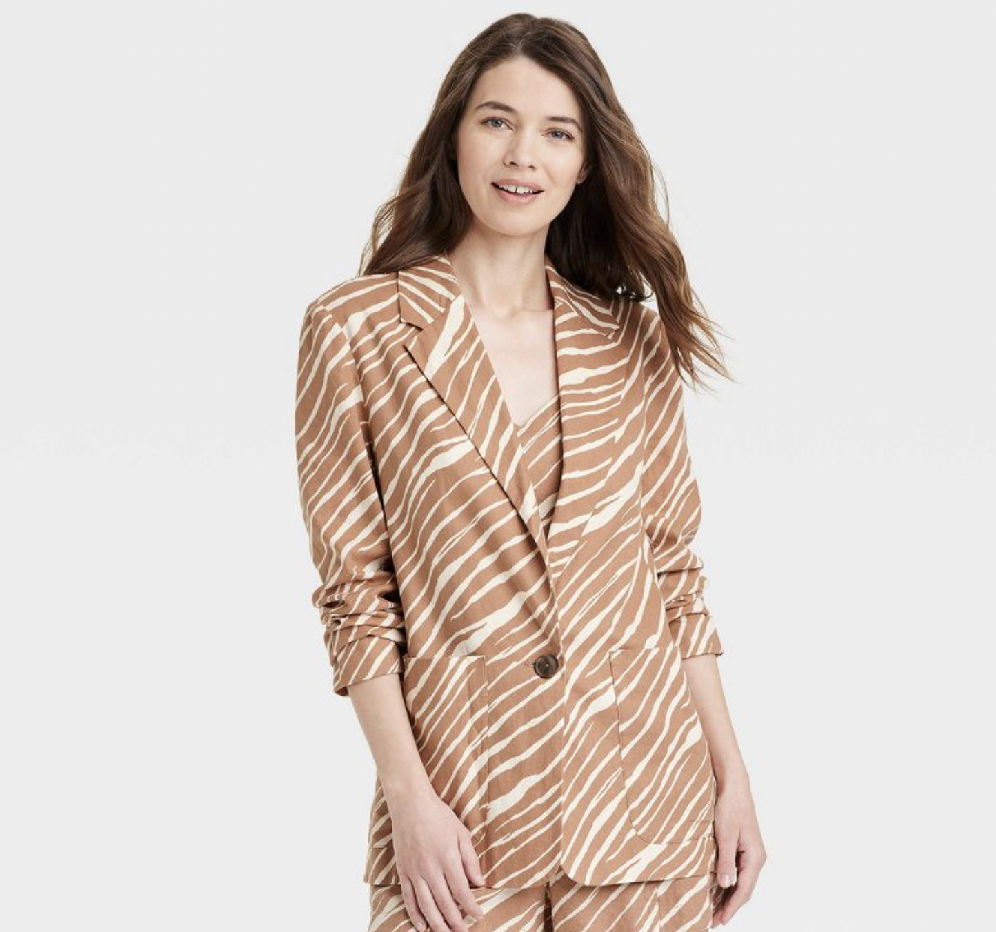A model wearing the blazer in a light brown zebra print