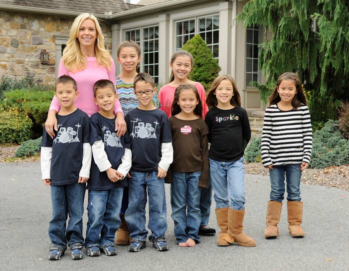Kate stands with the 8 kids in front of their house