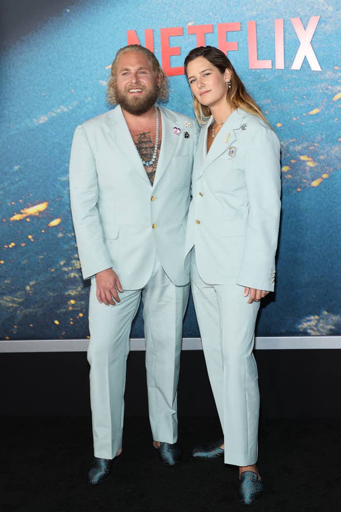 The former couple wearing identical pantsuits and loafers at a media event