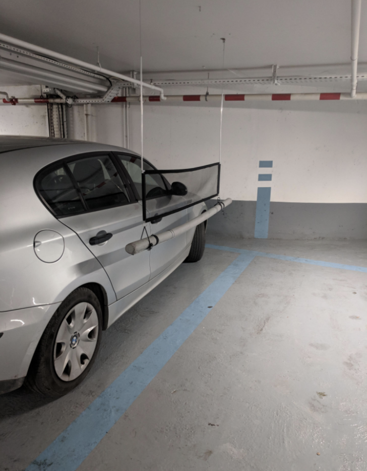 A soft beam hangs down from the ceiling and hovers over the line painted on the floor, indicating where the parking spot ends
