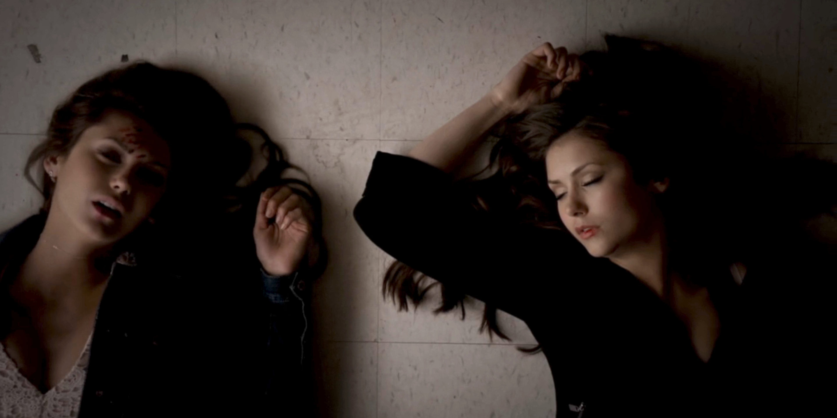 Elena and Katherine laying on the ground passed out