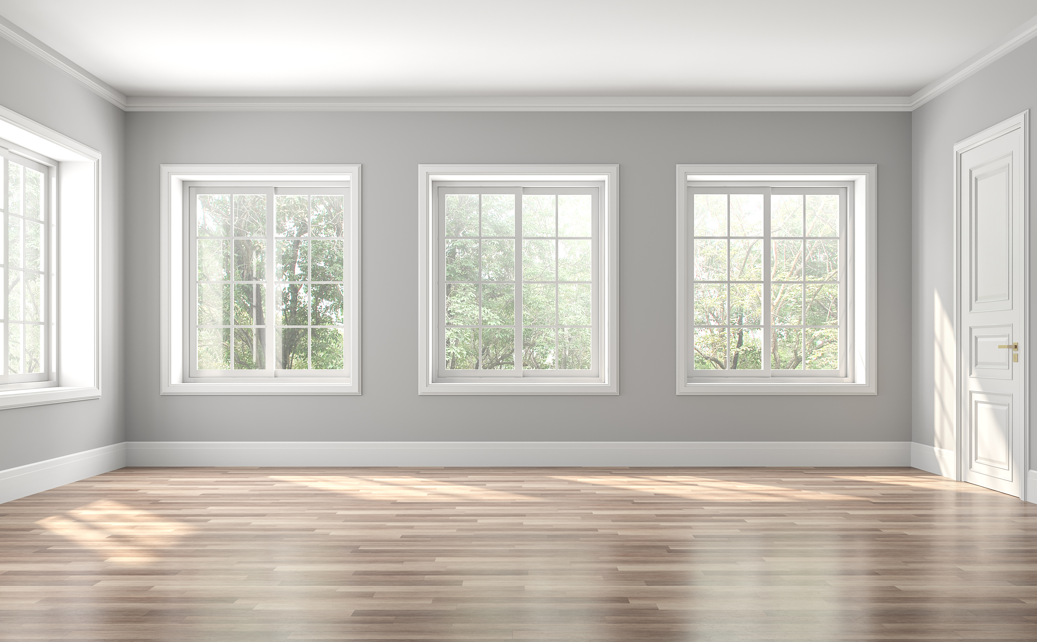 An empty room with gray walls and four windows