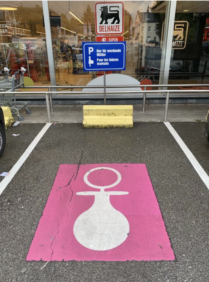 Similar to handicapped parking spots in the US, this spot is painted with a pink square with a pregnant woman inside it to indicate its reserved