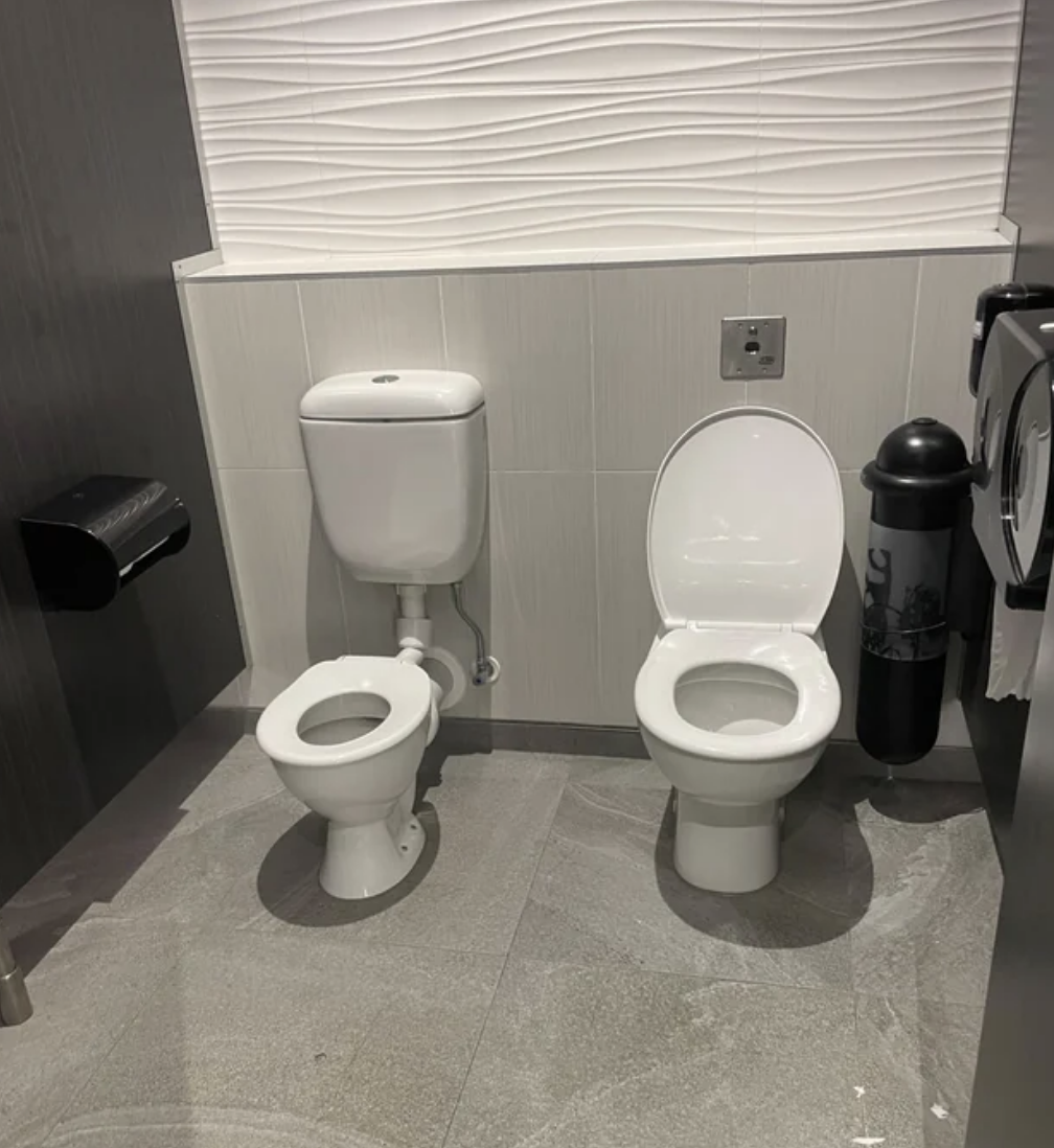 The stall is outfitted with two toilets; the one for adults is larger and flushes using a sensor, the one for children is smaller and must be flushed by hand