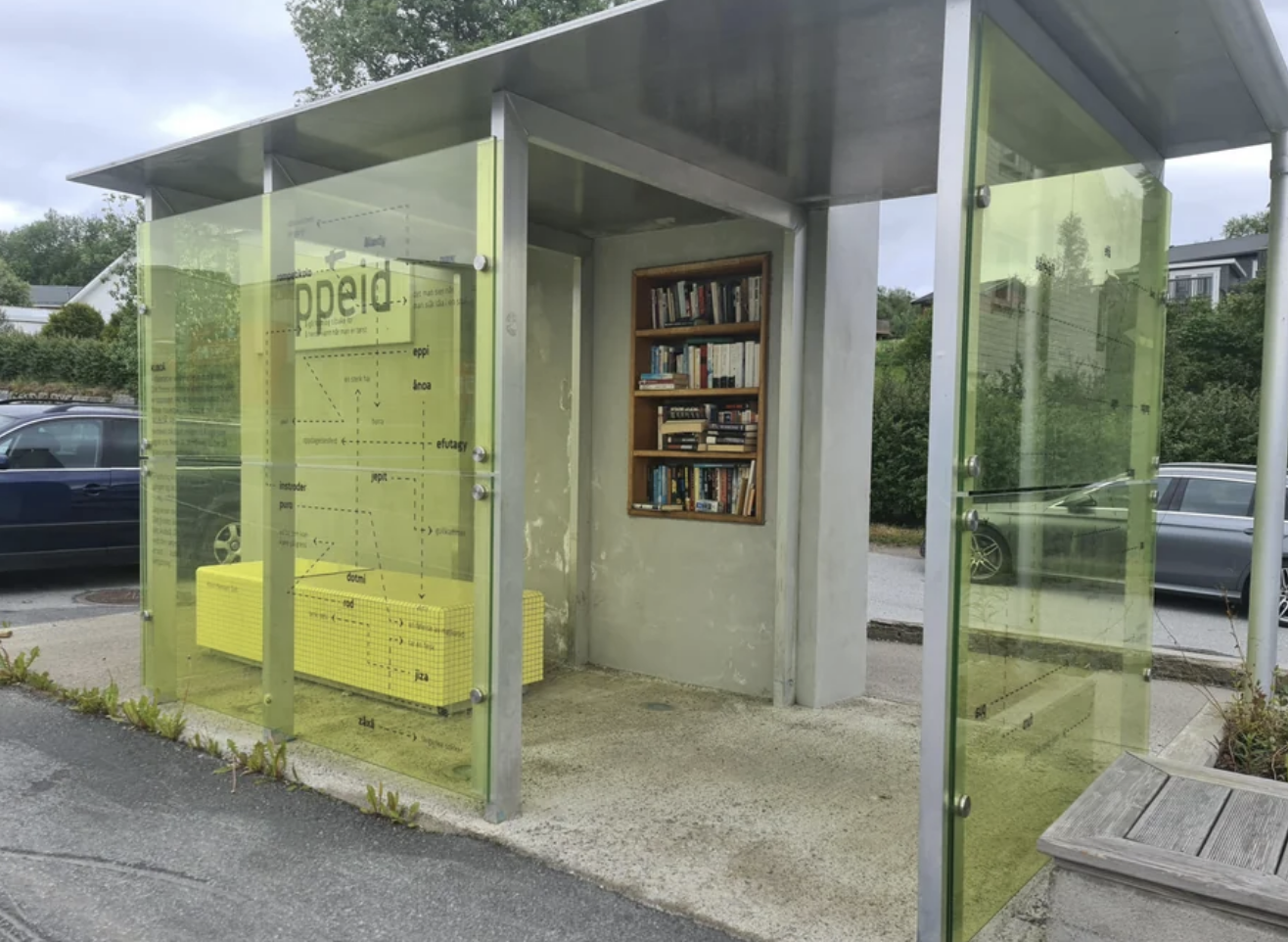 The bus stop is covered, so it&#x27;s protected from the elements, and has a book shelf filled with books built into the wall