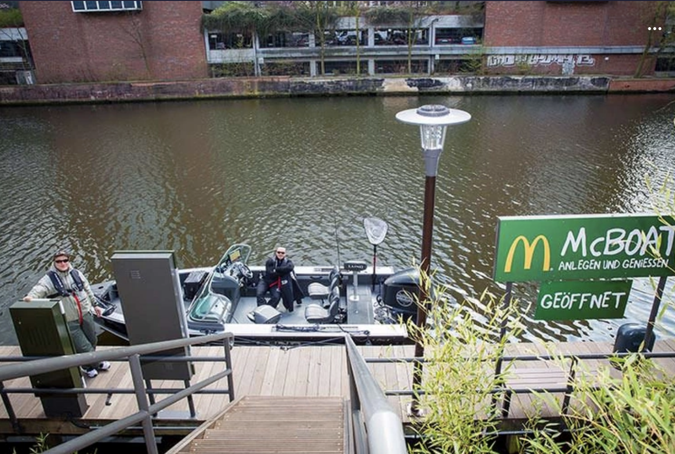 Someone on a boat is pulled up to a dock by McDonald&#x27;s and ordering food