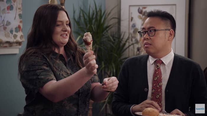 Dina from Superstore holds up a raw chicken leg