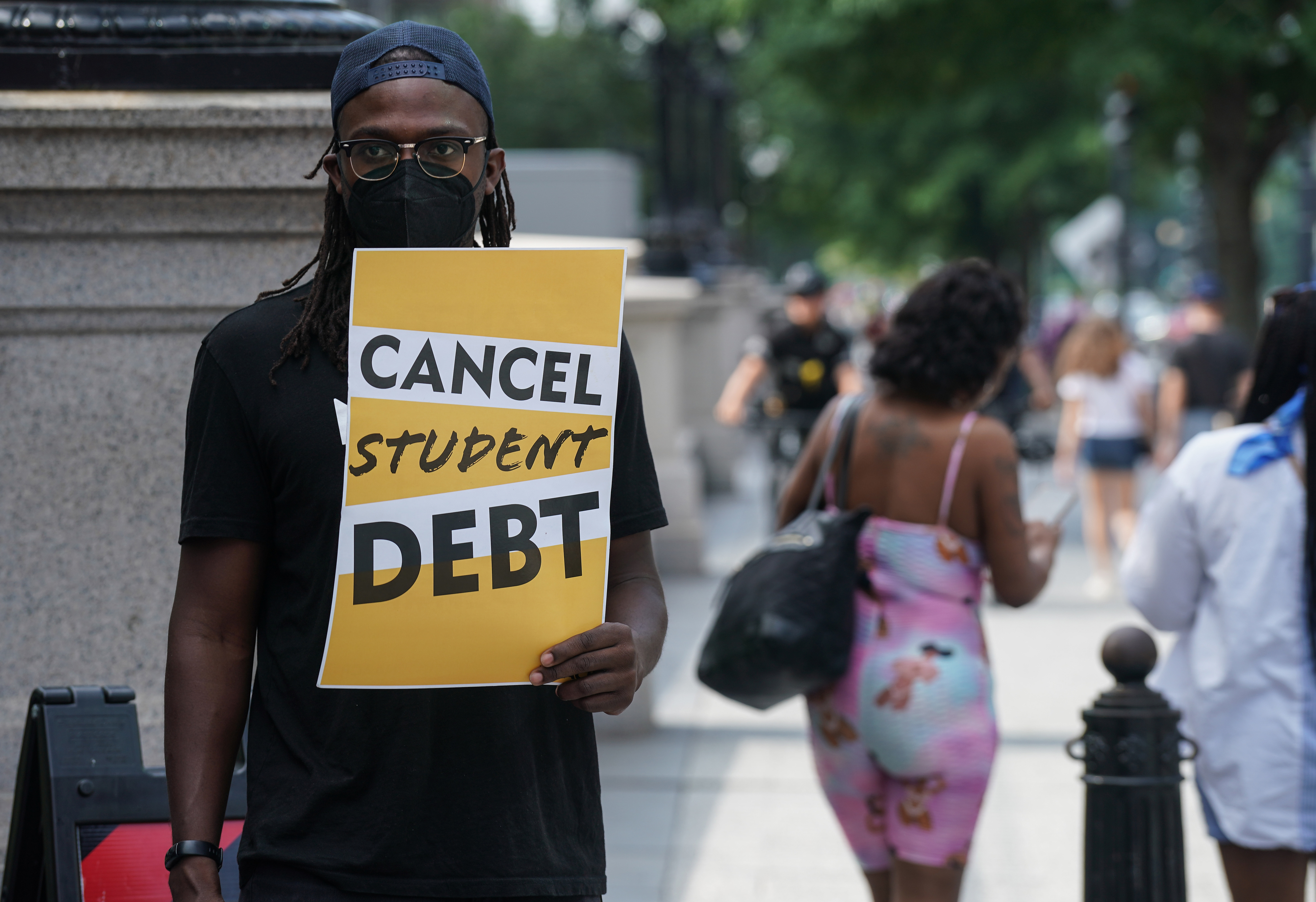 protester with a cancel student debt sign