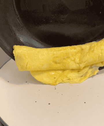 omelet neatly falling on to a white plate