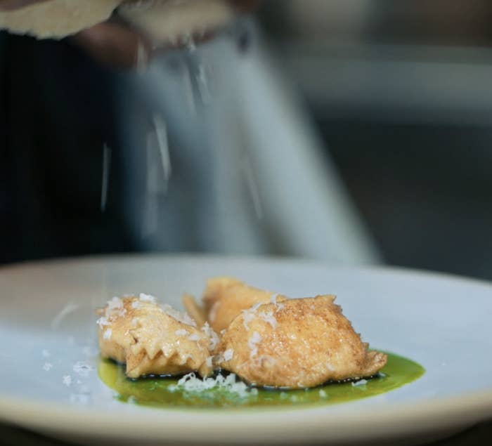 parmesan cheese garnishing brown butter pasta in an herb sauce