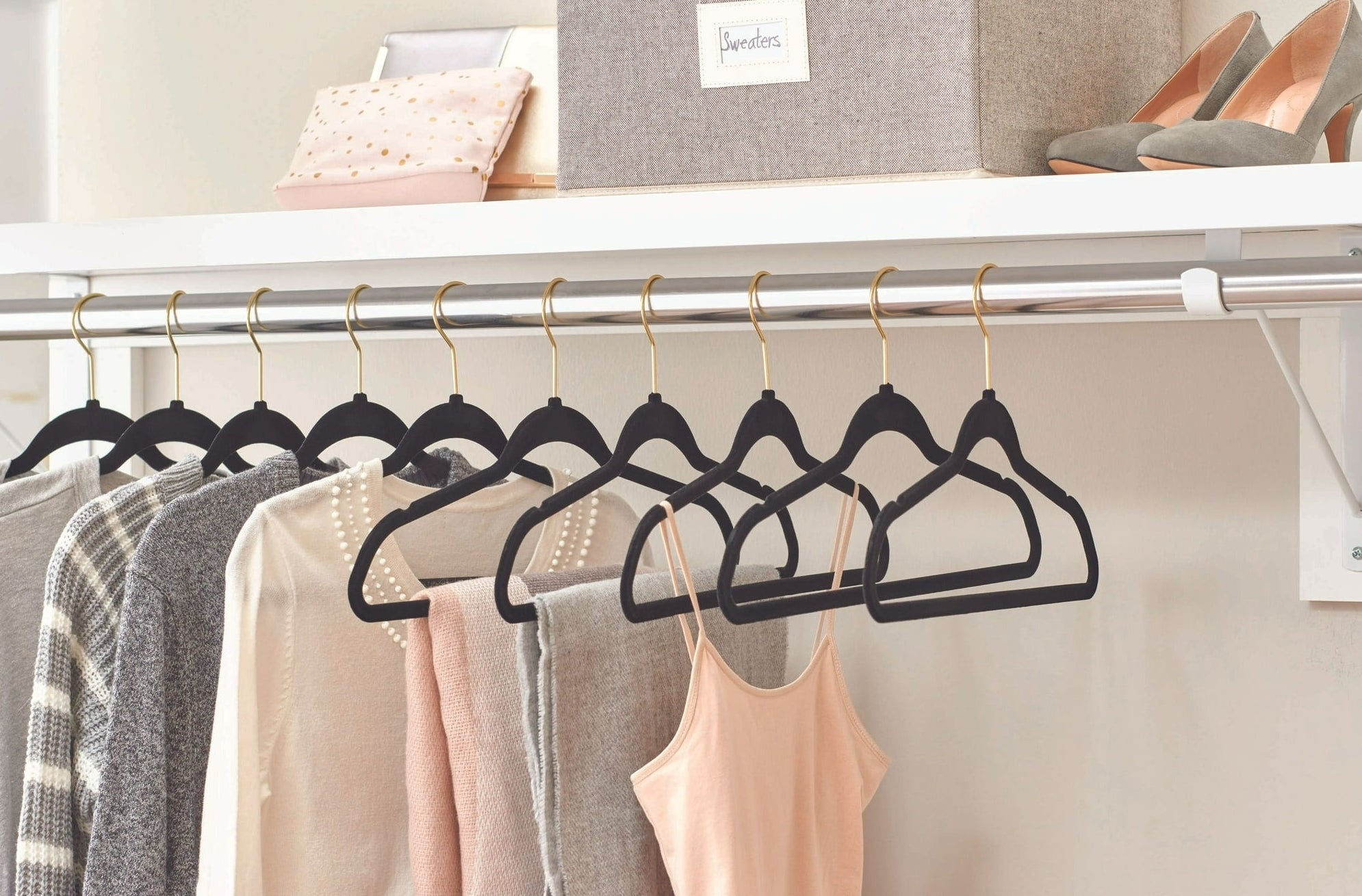 the hangers in a closet holding clothes