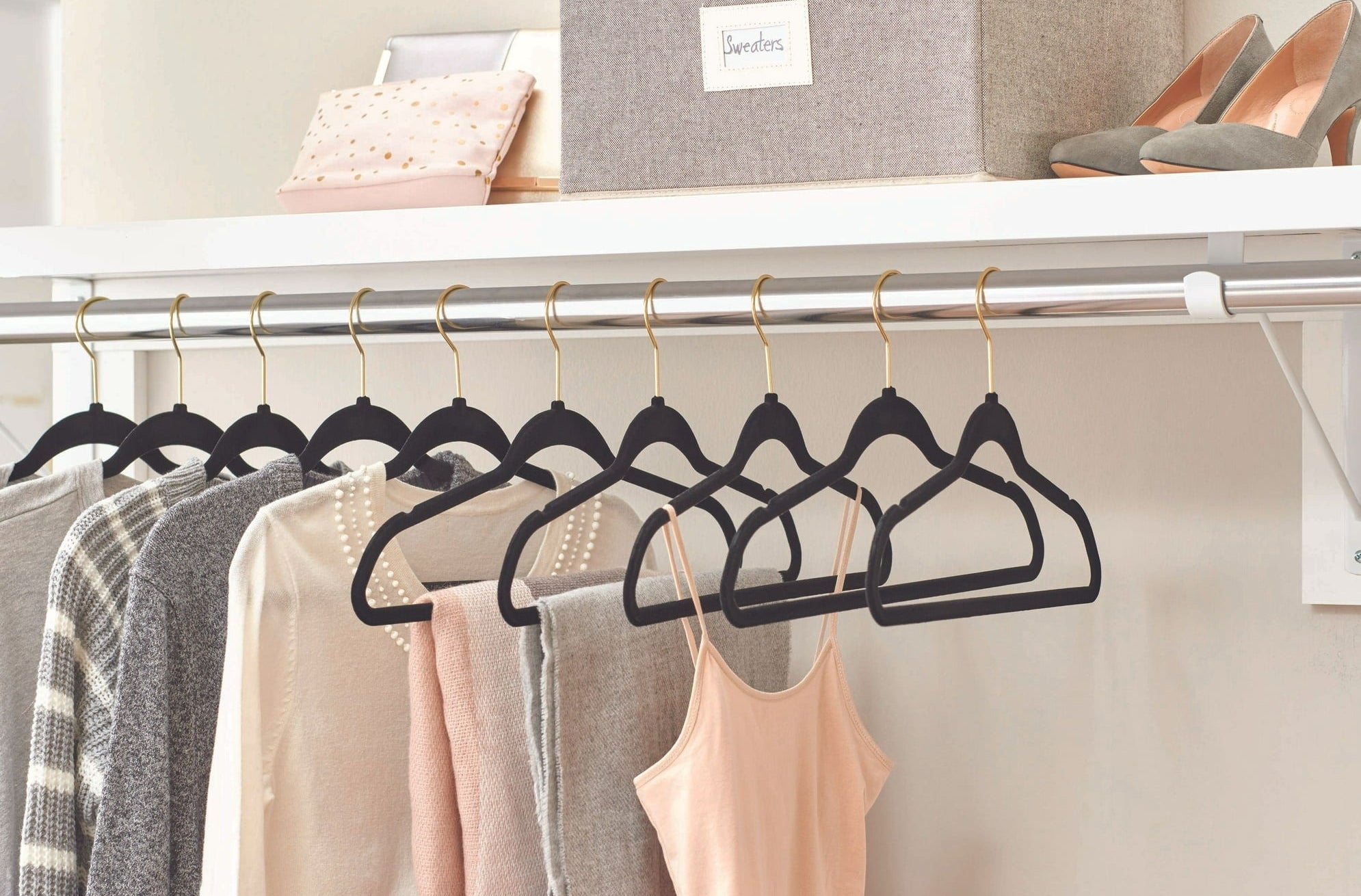the hangers in a closet holding clothes