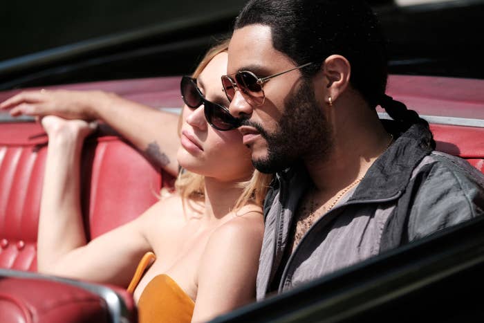 Lily-Rose Depp and The Weeknd sitting in the backseat of a convertible in The Idol. They are both wearing sunglasses