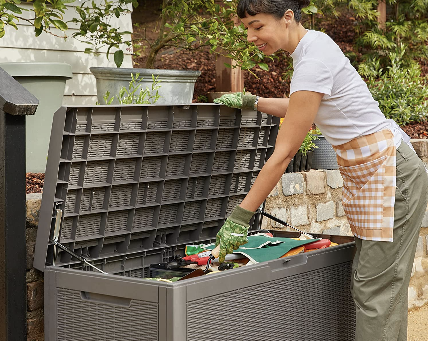 person grabbing gardening supplies from storage container
