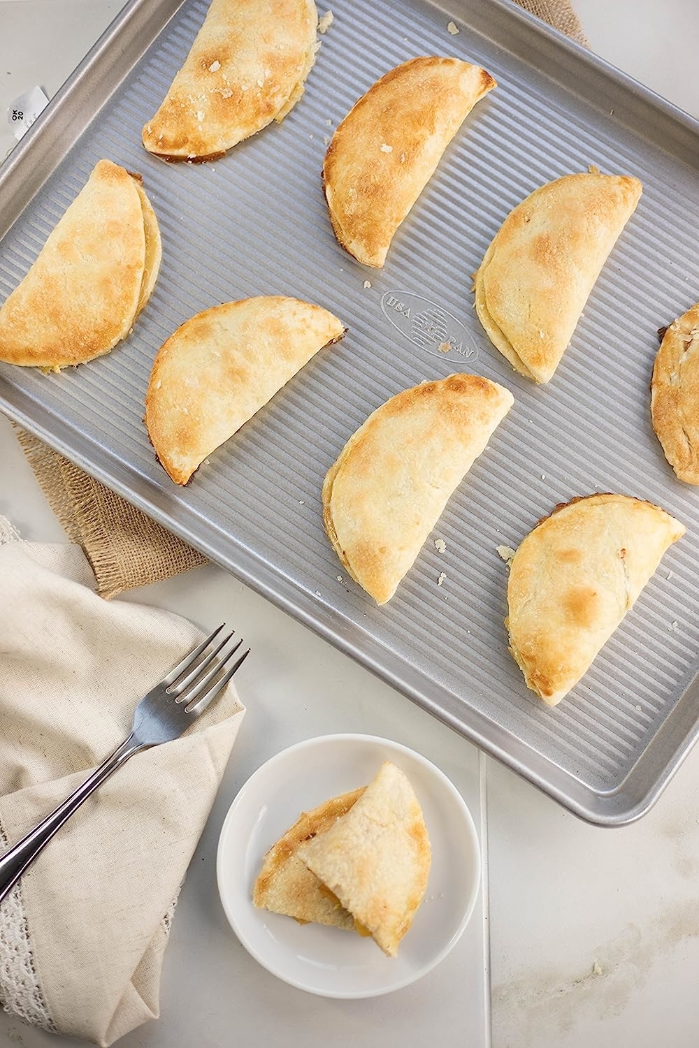 the half sheet pan with turnovers on it
