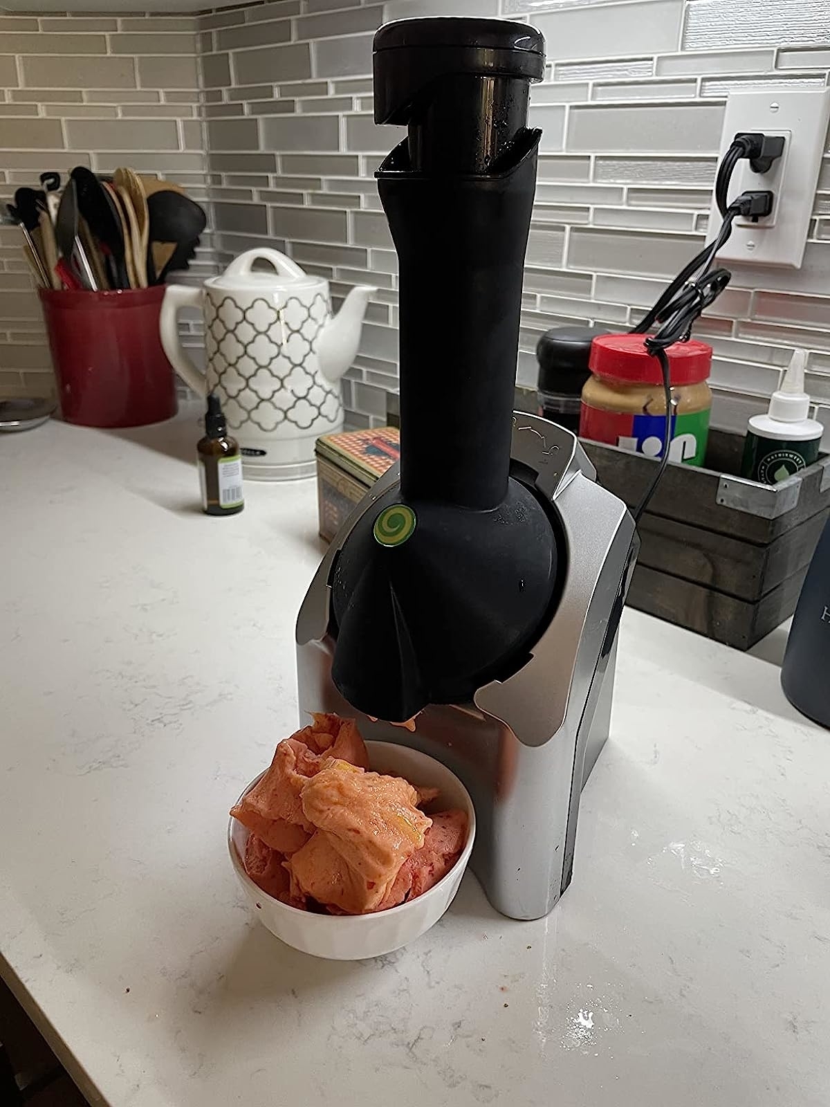 a reviewer photo of the deice next to a bowl of sorbet