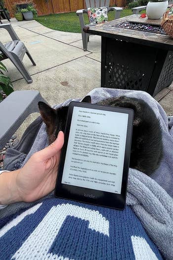reviewer reading kindle outside