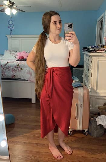reviewer with white ti-shirt bodysuit tucked into red skirt