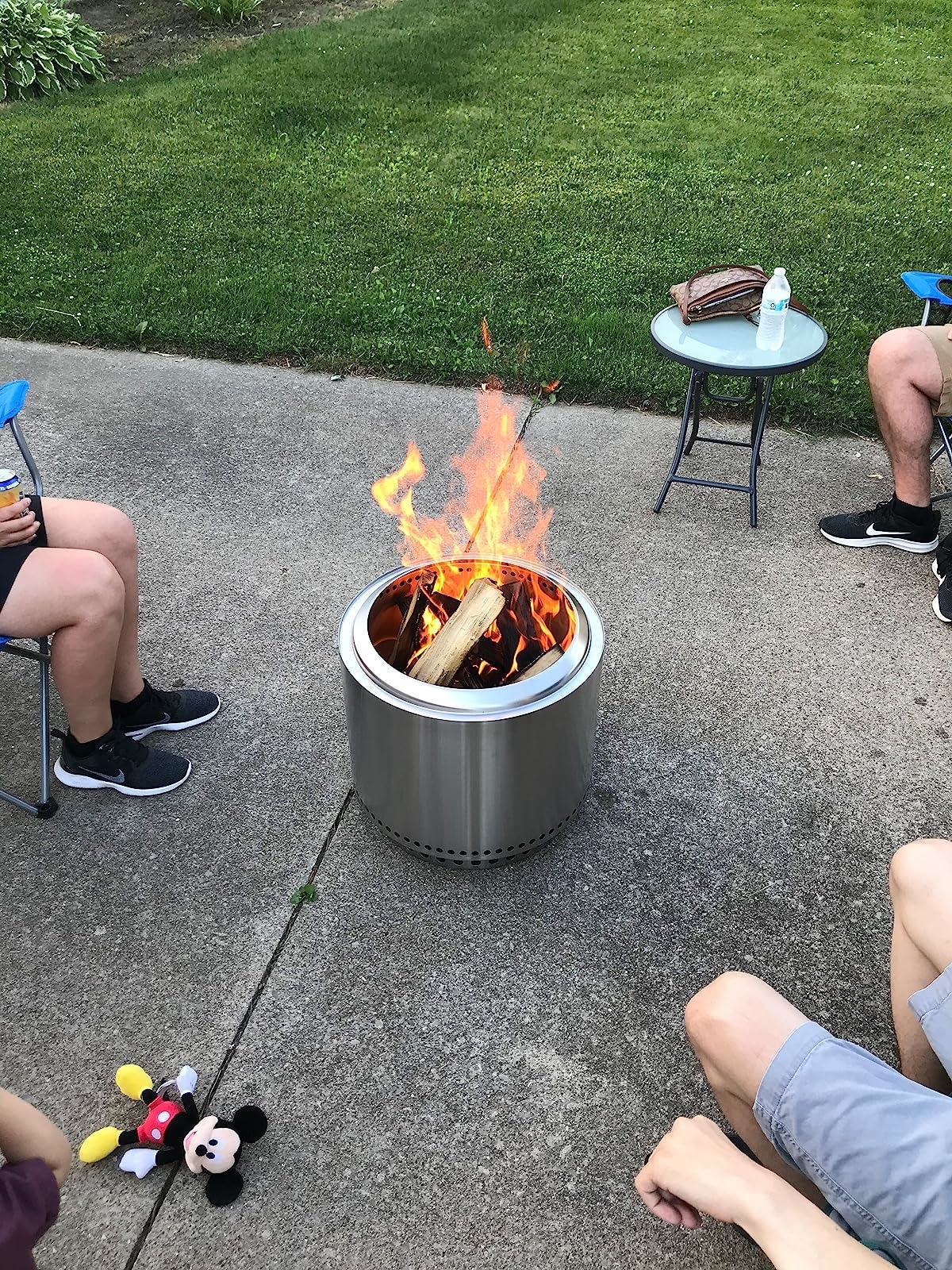 reviewer photo of people sitting around the solo stove on a driveway