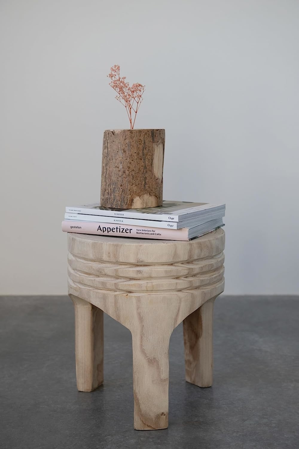 natural wood stool with books on top