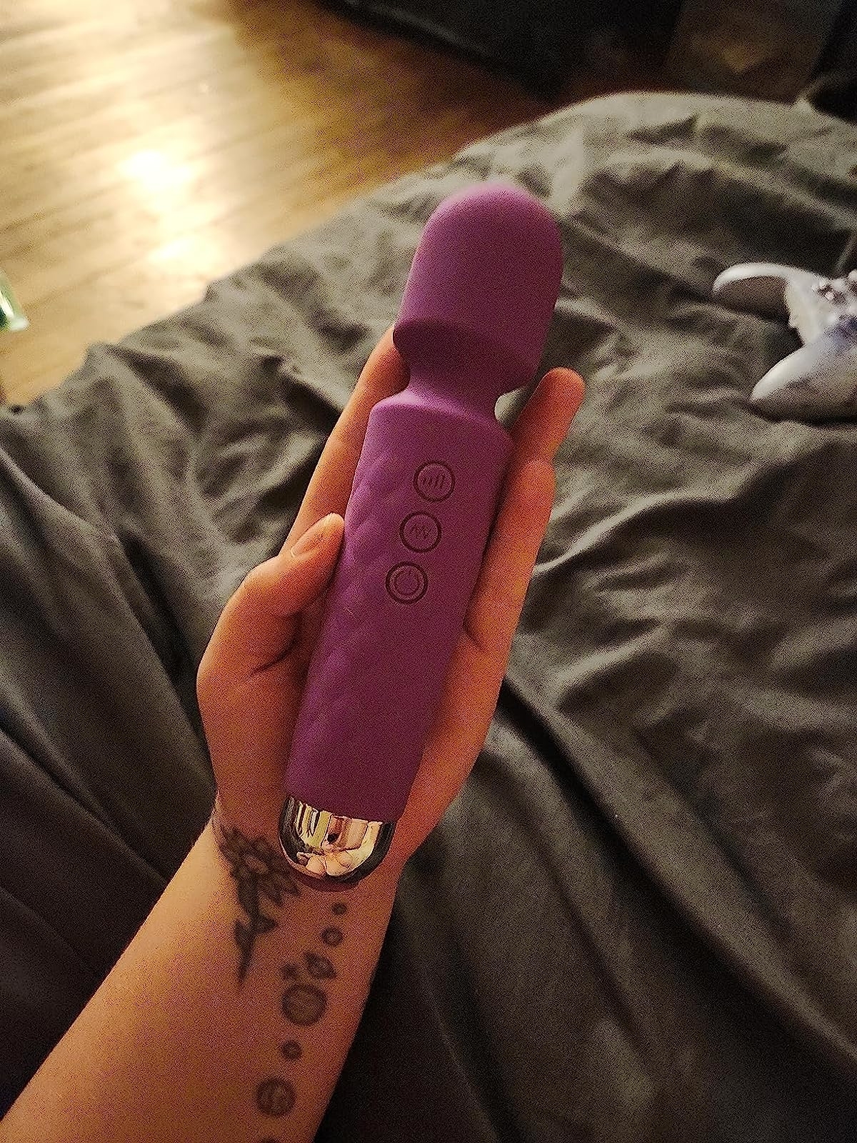 Hand holding purple mini wand vibrator