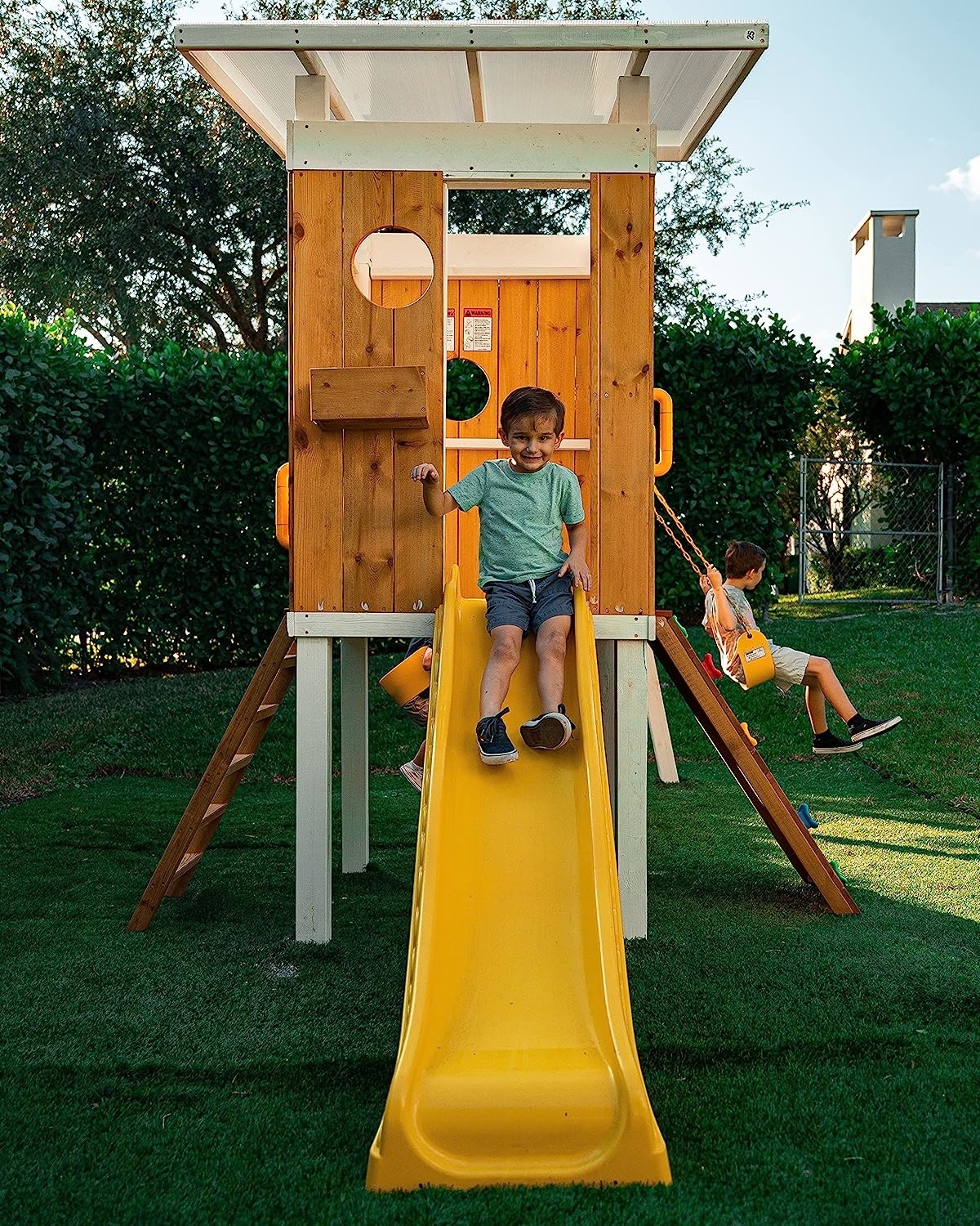 play set with swings, a rock wall, ladder, slide, and more